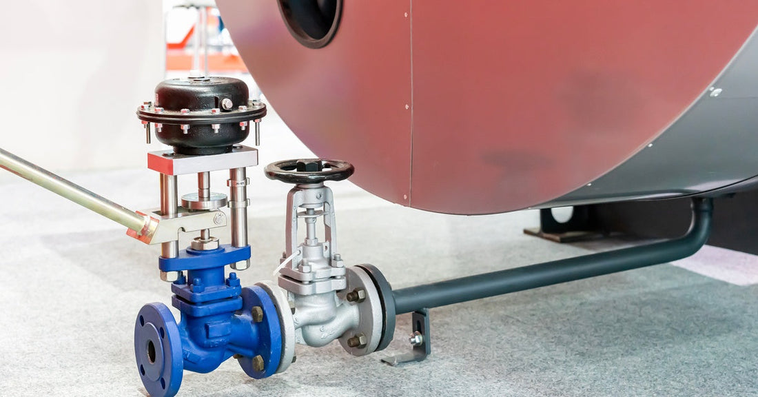 Close-up of an automatic and manual blowdown valve connected to a boiler system in an industrial setting.