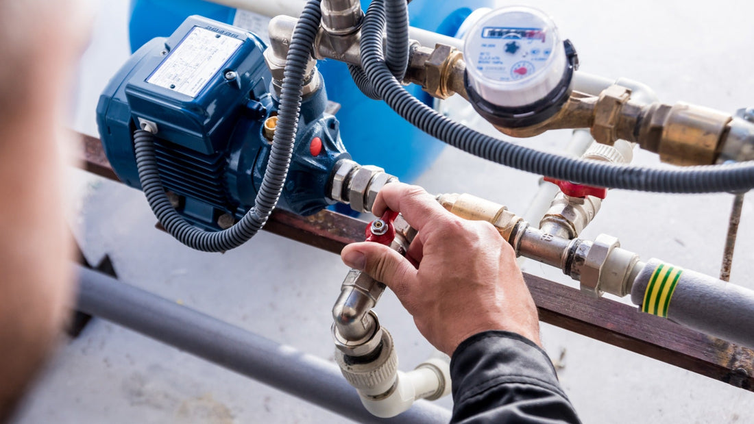 A technician at the valve system turning the check valve. There is a pressure gauge mounted on the pipeline.